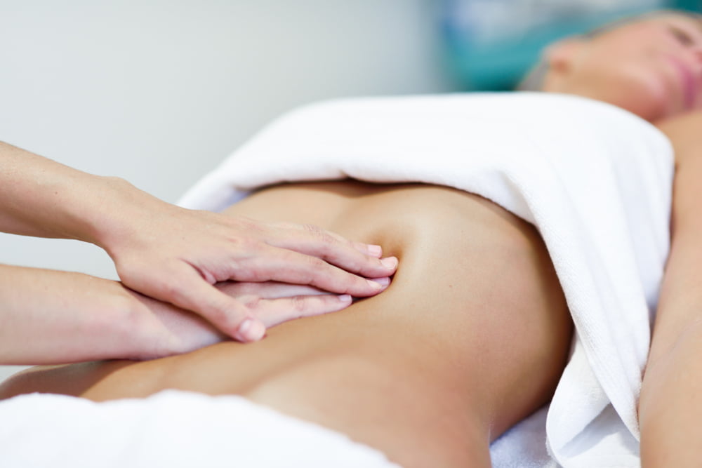 5 melhores massagens feitas em SPA 2 hands massaging female abdomen therapist applying pressure belly