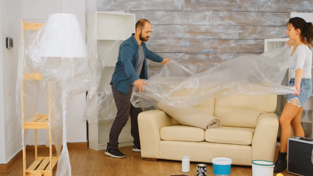 Passo a passo de como impermeabilizar sofás e estofados sem manchar 2 couple wrapping sofa plastic foil protection while they are renovate living room home renovation construction painting work