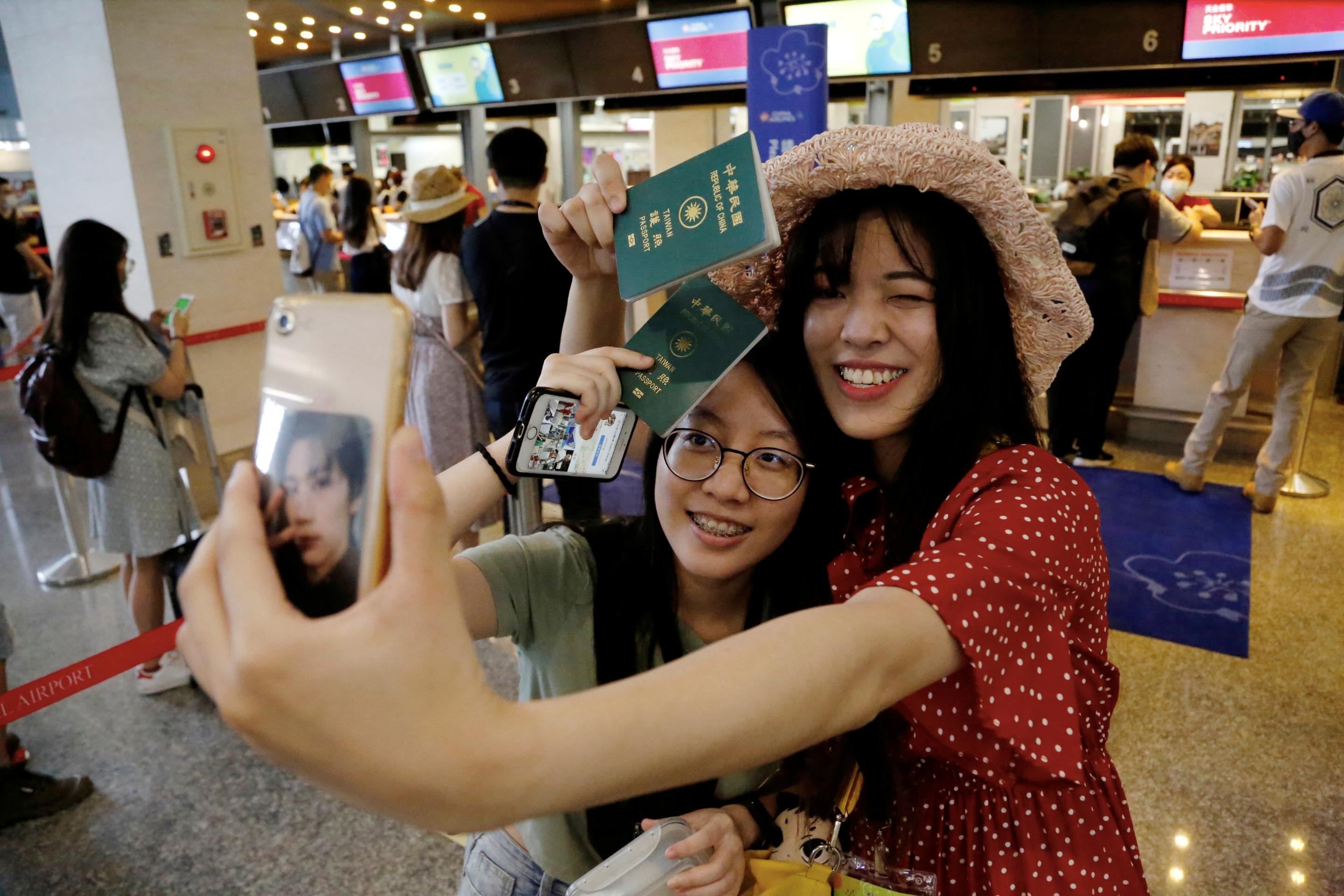 Taiwan começou "Voos Fantásticos" Para aqueles que querem satisfazer seu desejo de viajar 3 duas garotas tiram uma selfie em um aeroporto em taiwan