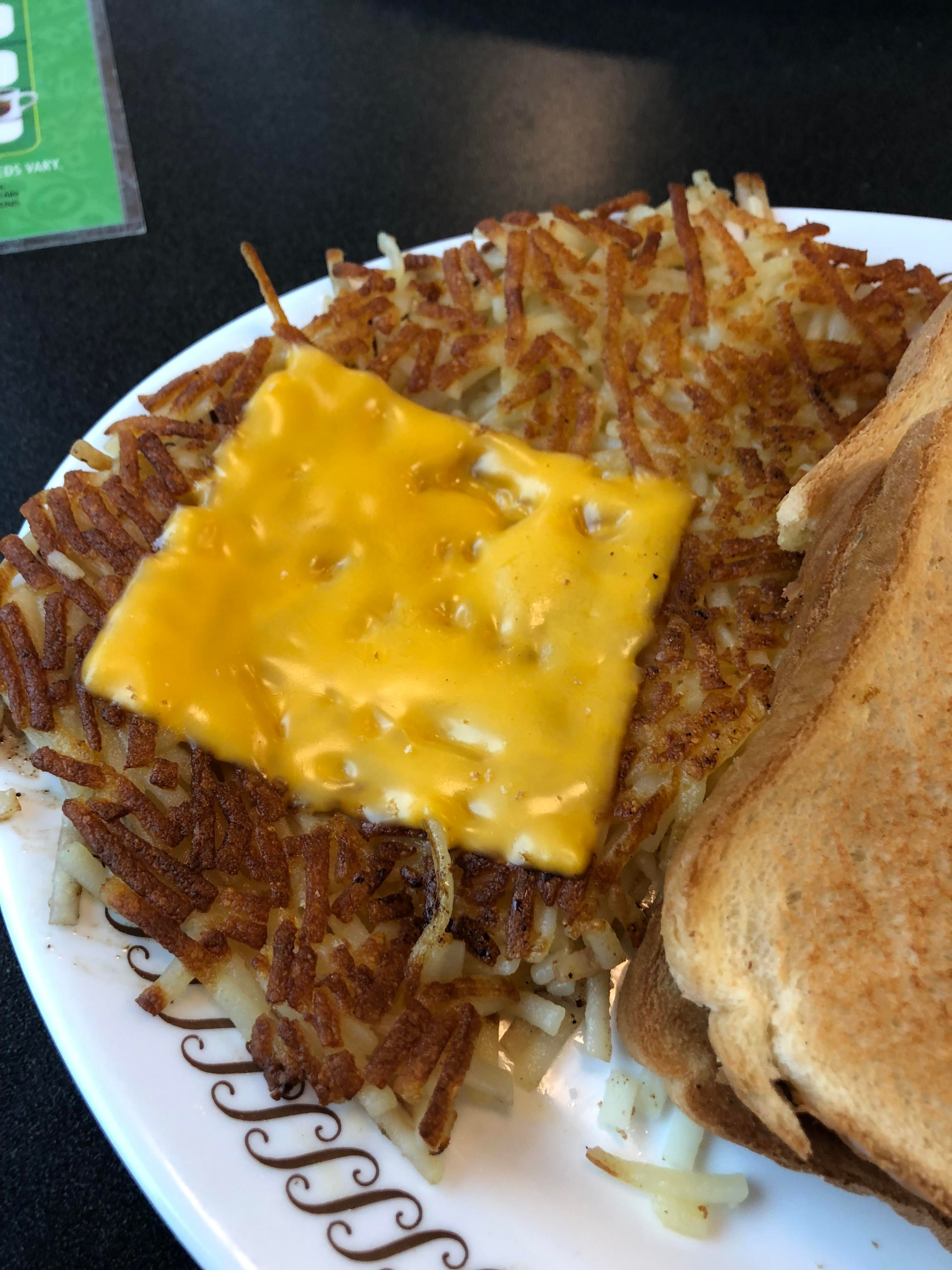 Pratos mais pedidos em restaurantes dos EUA 3 batatas fritas com pedaço de queijo por cima no prato waffle house