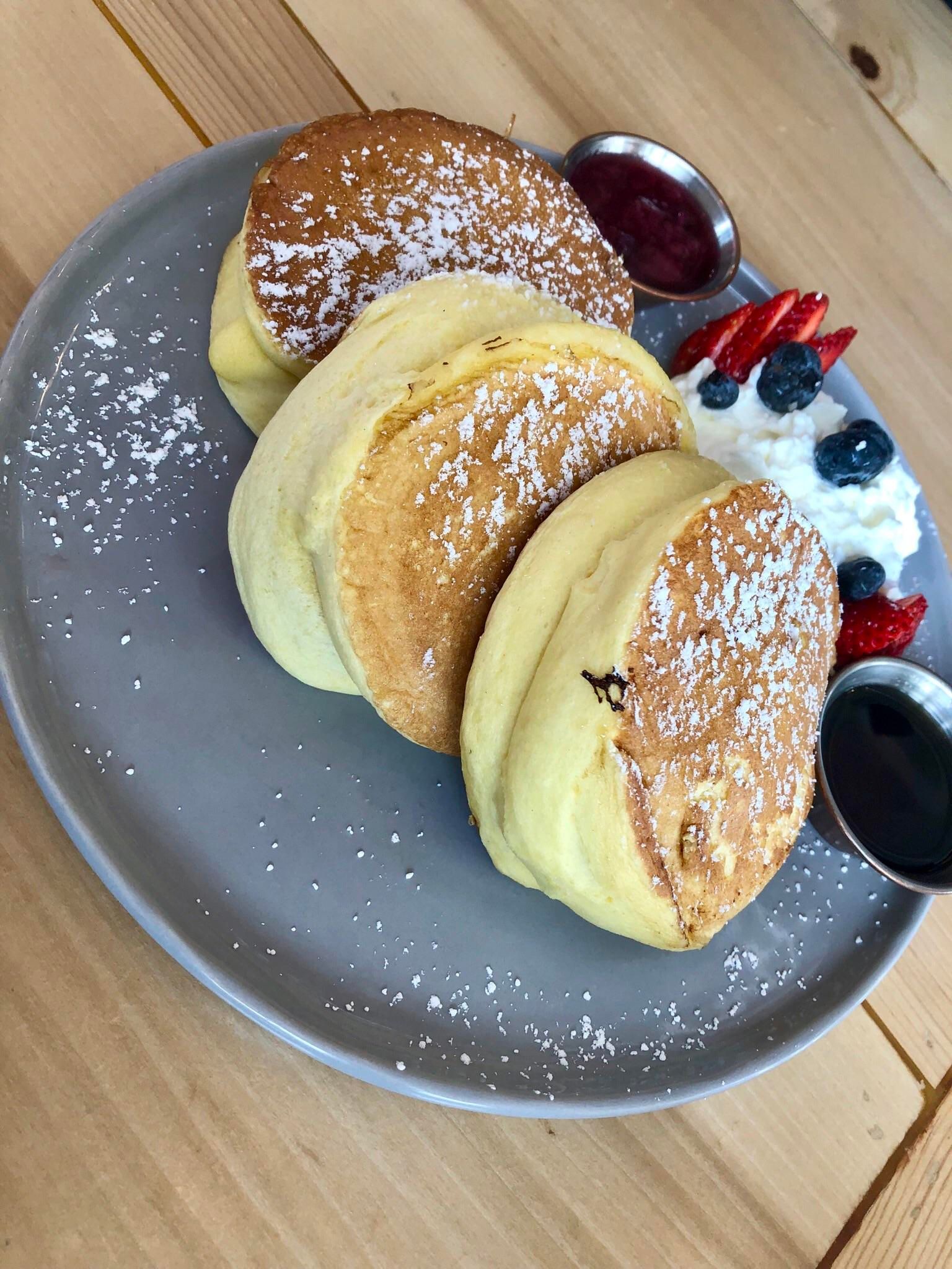 Você vai querer viajar para essas deliciosas sobremesas japonesas 5 panquecas fofas no japão no prato azul com frutas ao lado