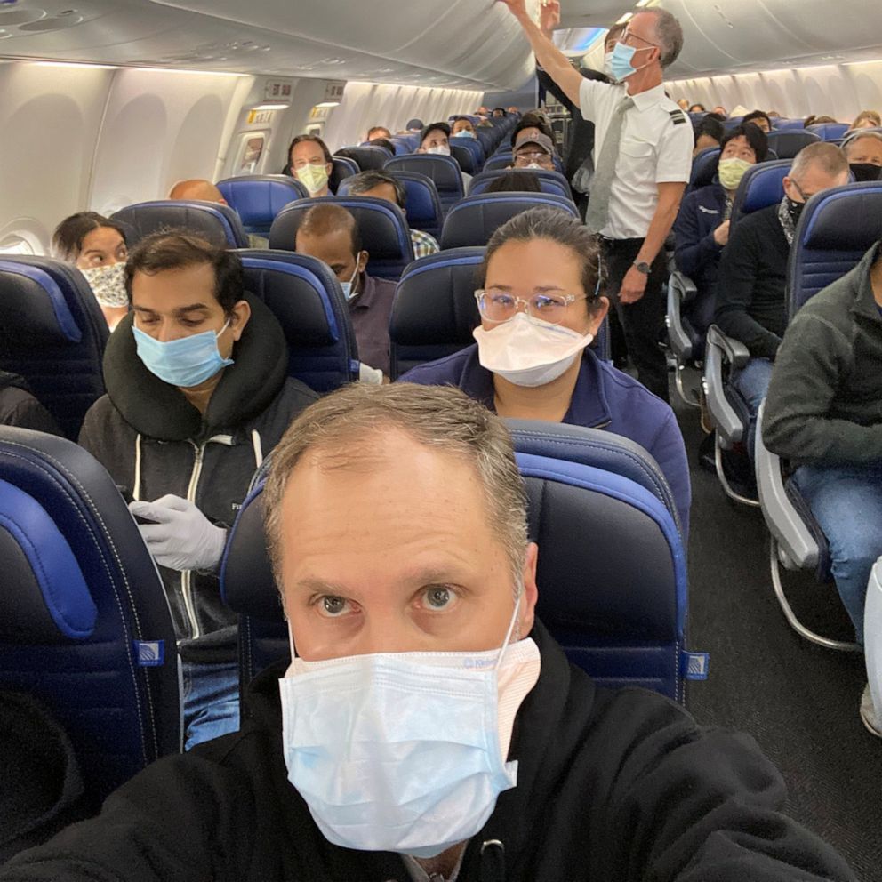 passageiros em um avião com máscaras faciais