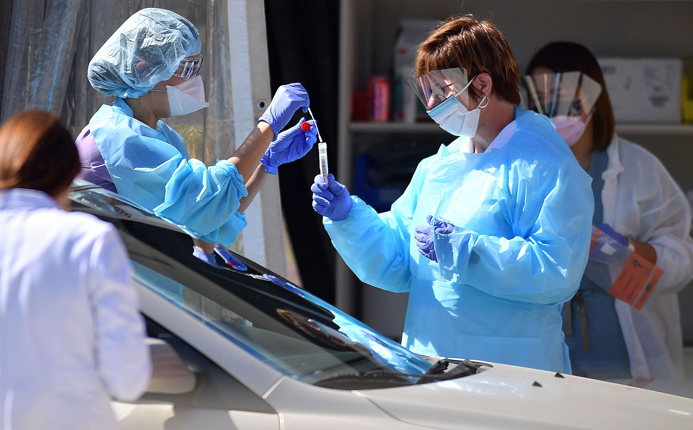 COVID-19 e Coreia do Sul: o que todos podemos aprender com a maneira como eles lidaram com isso 4 equipes médicas testando motoristas e passageiros em um centro de testes drive-thru