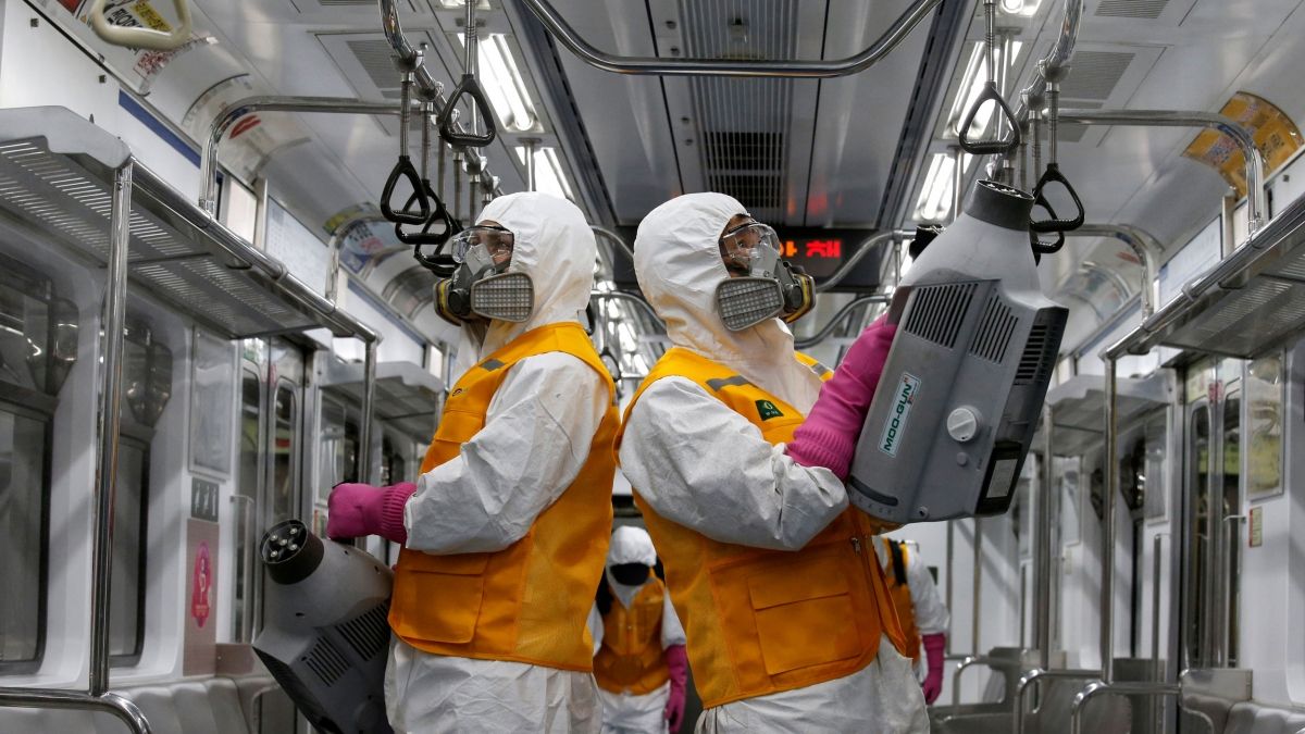 uma equipe em equipamento de proteção higieniza e desinfeta um vagão de metrô de transporte público
