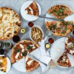 a table full of different pizza