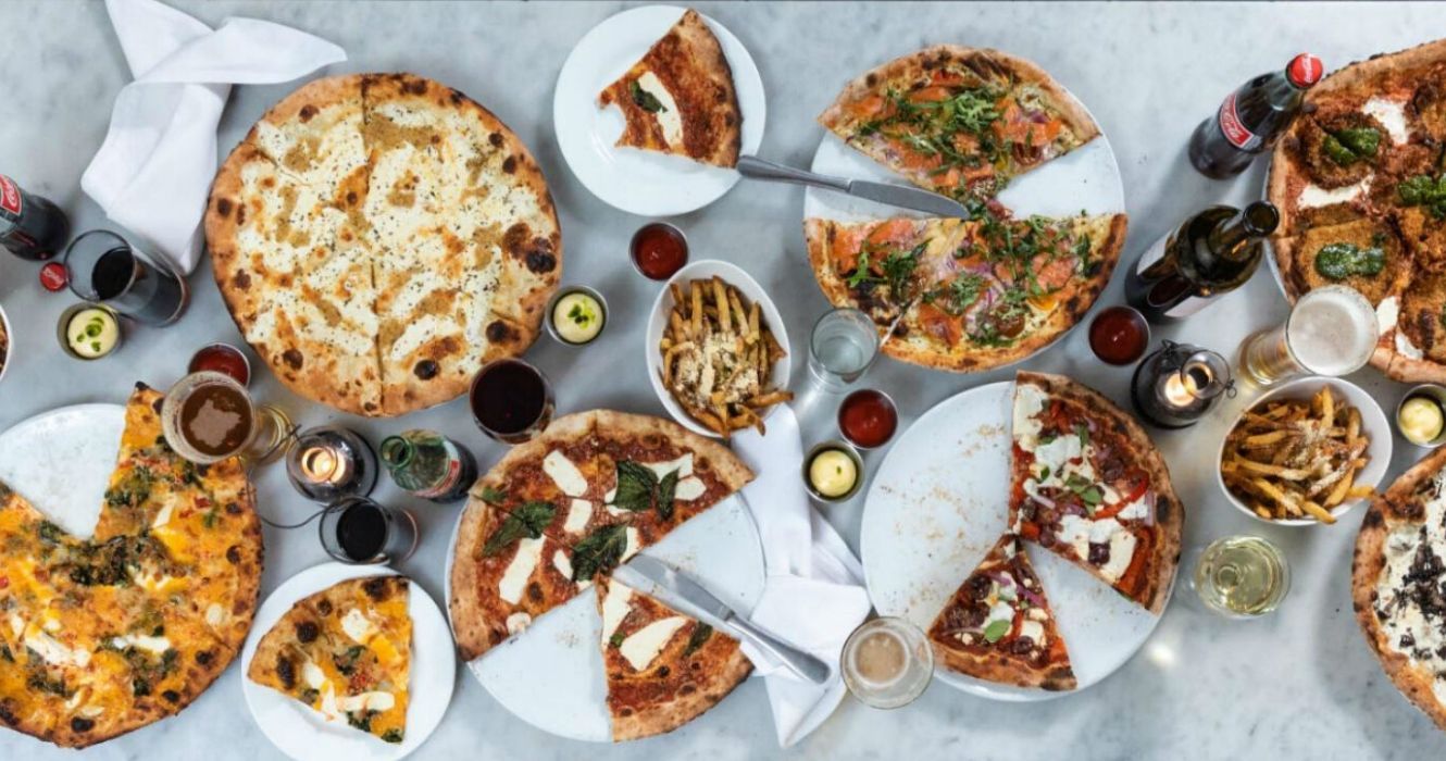 uma mesa cheia de pizza diferente