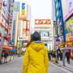 a girl stands in the middle of a street in asia