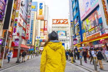 a girl stands in the middle of a street in asia