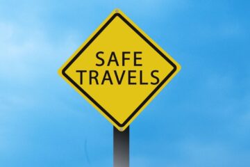 Yellow safe travel sign against blue sky