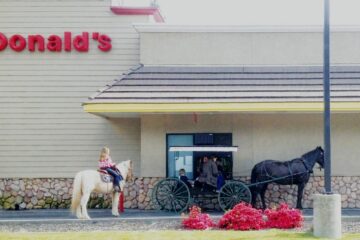 People with horses and a carriage at a McDonald's drive-thru
