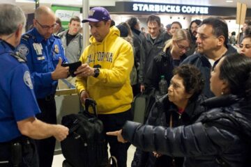 TSA agents and passengers at airport security
