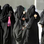 a group of women in saudi arabia walk down the street in traditional wear
