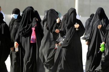 a group of women in saudi arabia walk down the street in traditional wear