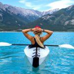 a woman goes kayaking in the mountains