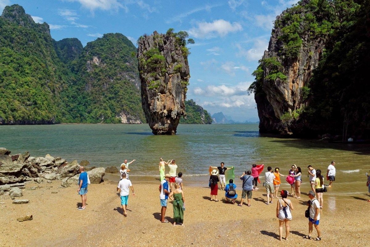Os turistas lotaram esses destinos por causa dos filmes (e ficaram desapontados) 3 Um grupo de pessoas em um Bech na Tailândia, onde muitos filmes foram filmados.