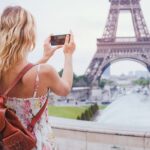 a traveler taking a photo of the eiffel tower