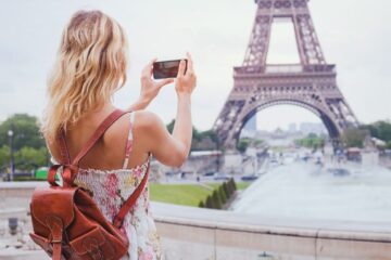 a traveler taking a photo of the eiffel tower
