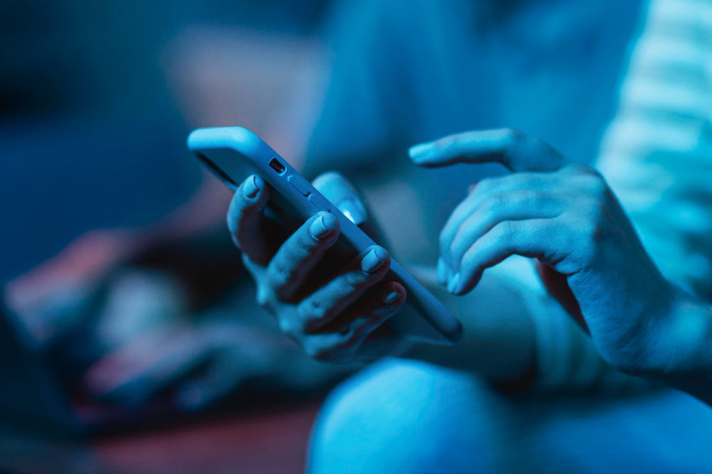 6 dicas de como liberar espaço no celular e deixá-lo mais rápido 3 woman using her smartphone while home