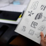 hand holding notebook with drew brand logo creative design ideas